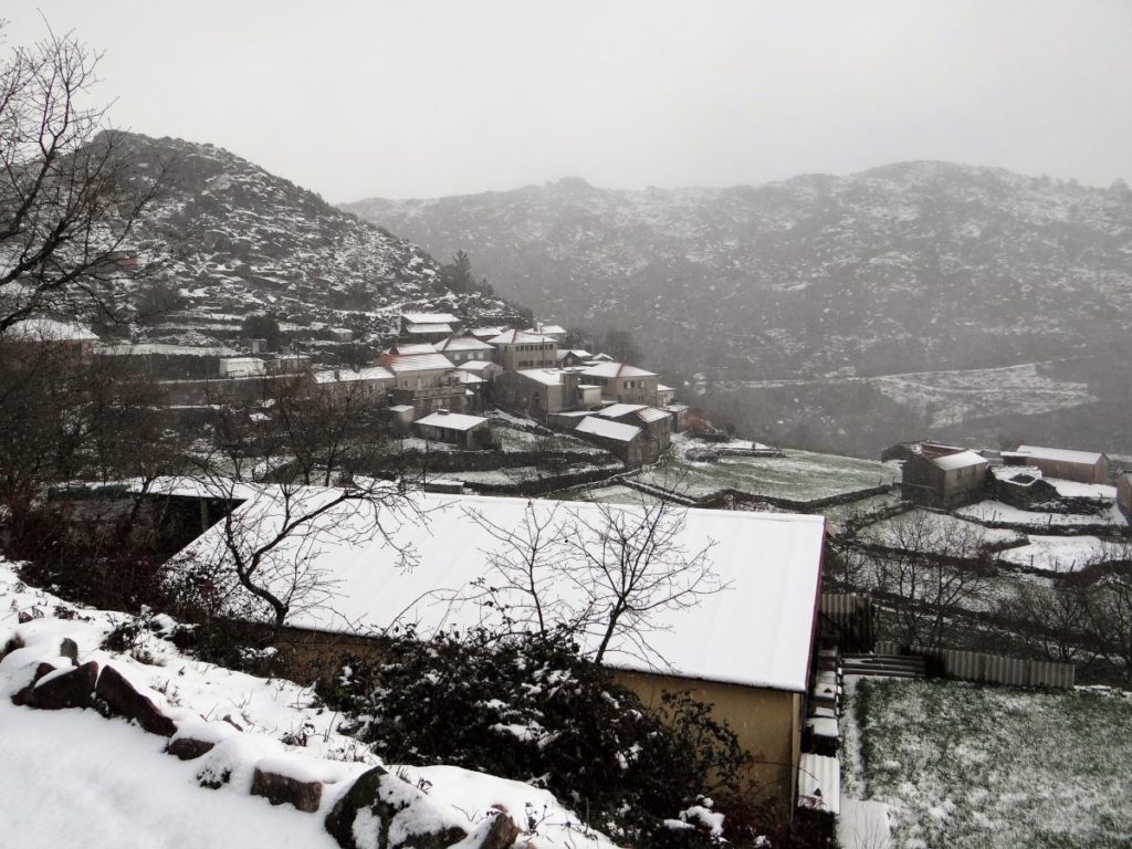 Vista para uma aldeia coberta de neve, na Serra da Freita